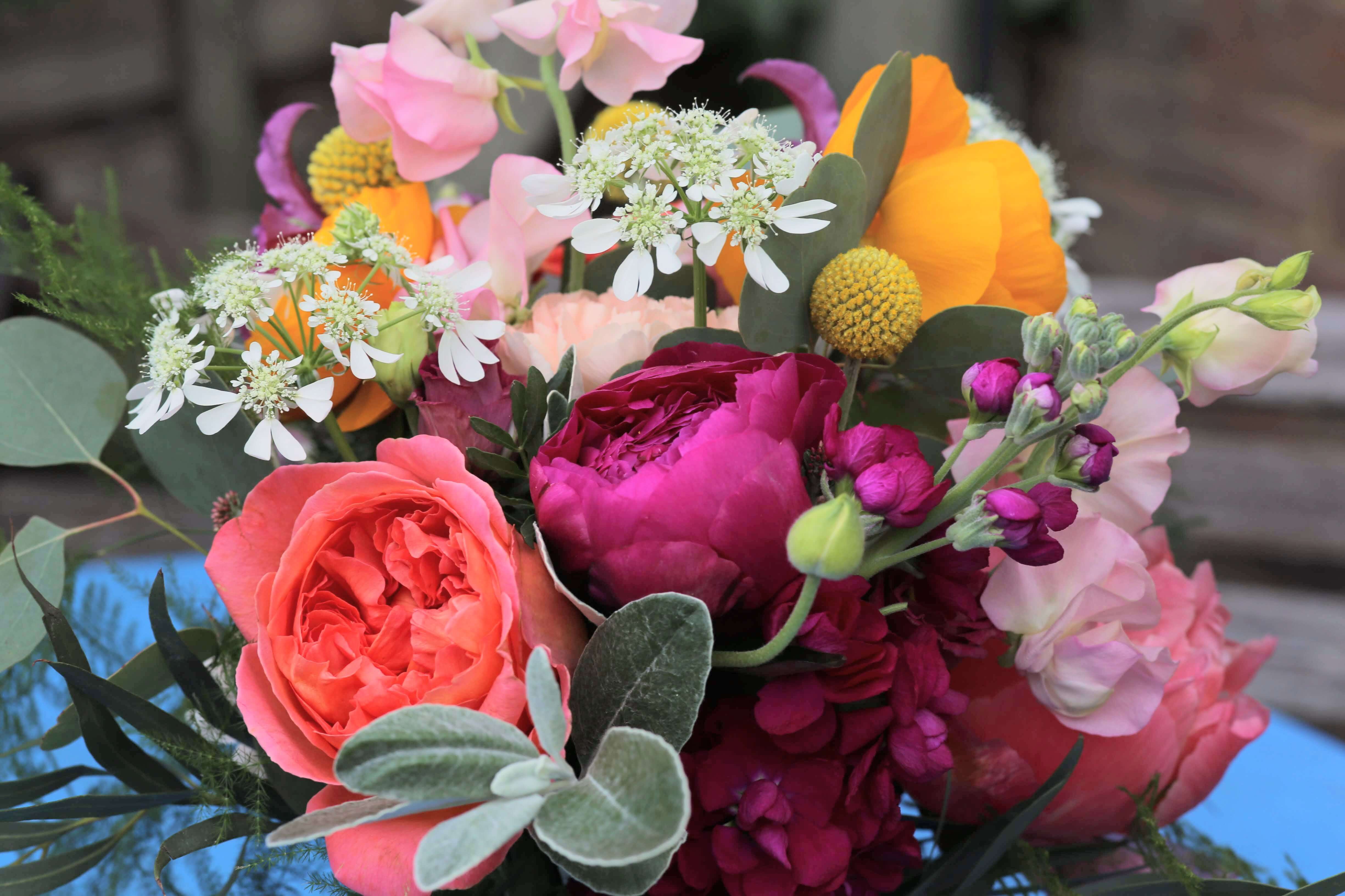 Bright and colourful bridal bouquet with peonies, ranunculus and garden roses by Bettie Rose Flowers, Sussex wedding florist