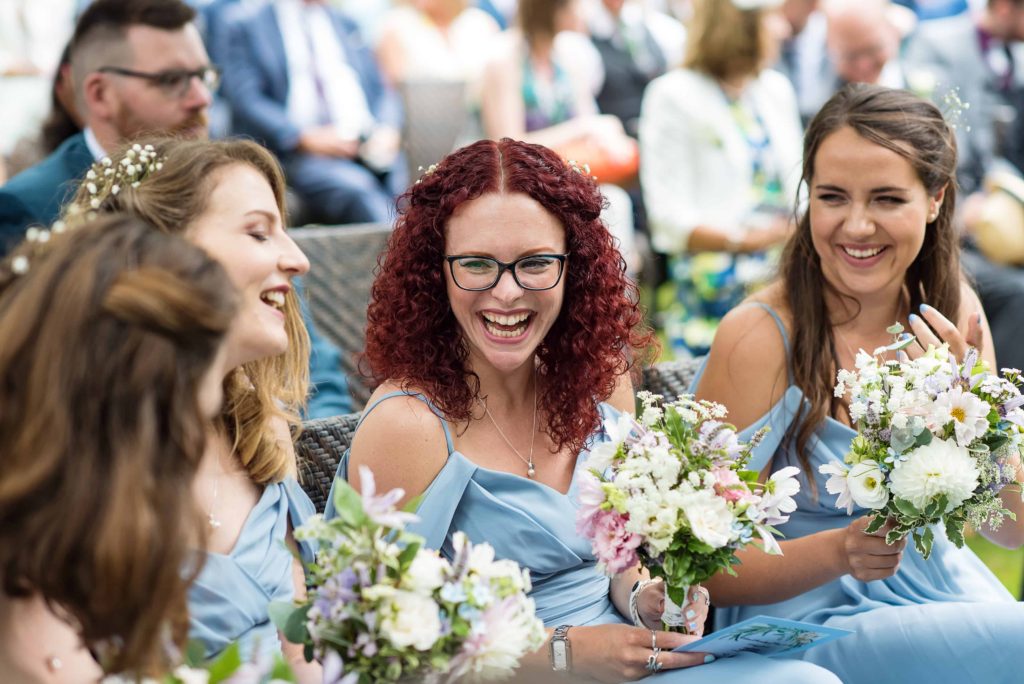 Laughing bridesmaids at Pangdean Barn outdoor wedding 