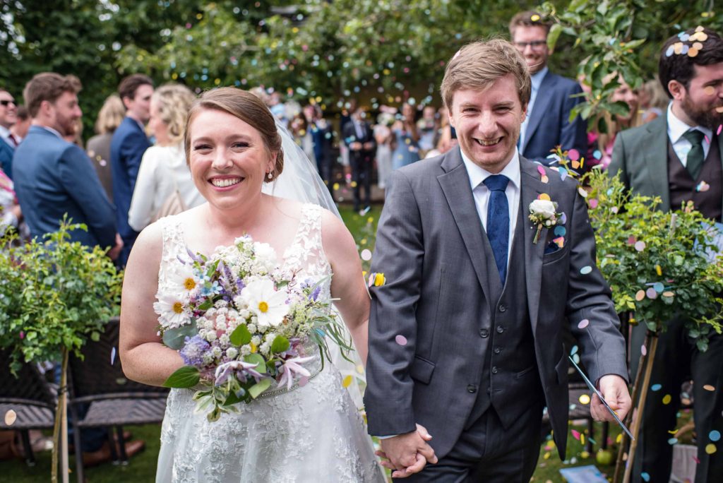 Outdoor wedding with bride and groom walking down the aisle 