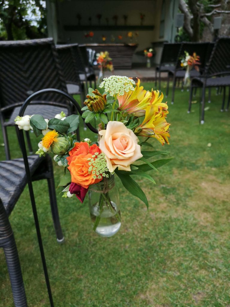 outdoor wedding at pangdean barn with flowers on shepherd hooks down the aisle