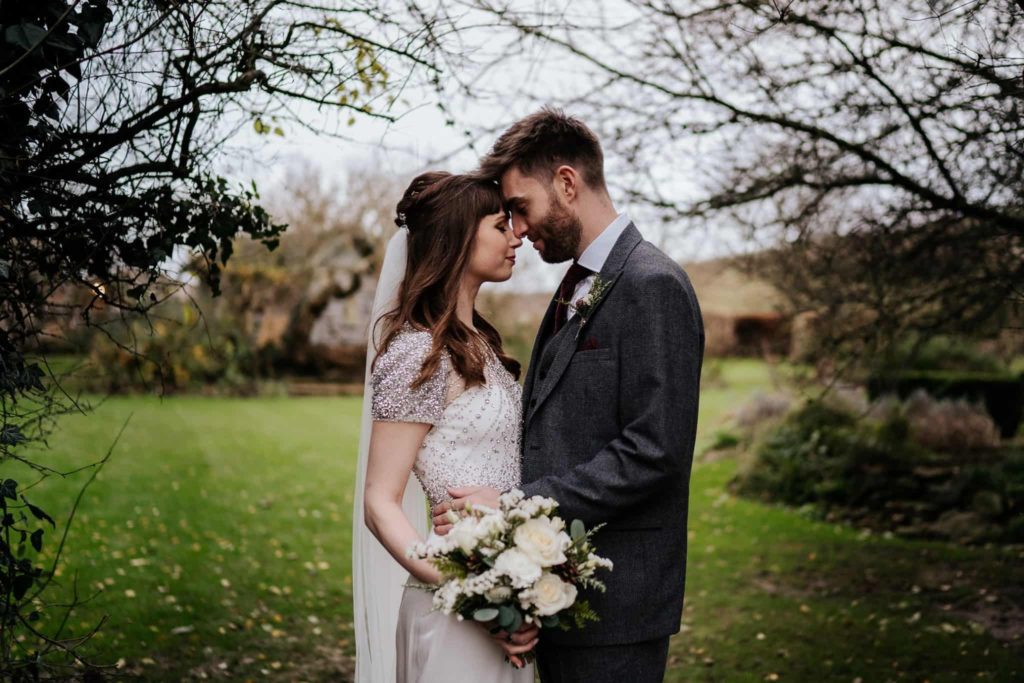 Bride and groom with flowers at Pangdean Barn